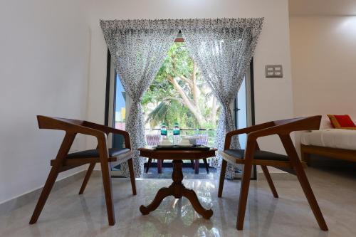 a room with two chairs and a table and a window at Star Eden Residency in Virāmpattinam