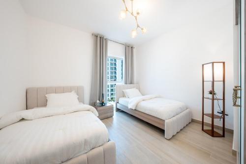 阿布扎比Luxury New 2BDR On Yas Island的一间带两张床和一扇窗户的白色卧室