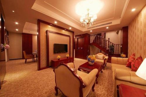 a living room with couches and a tv and a mirror at New Century Hotel Putuo Zhoushan in Zhoushan