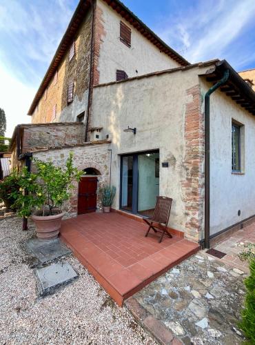 a patio in front of a building with a bench at Podere Le Grotte in San Gimignano