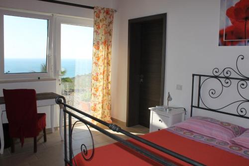 a bedroom with a bed and a desk and a window at B&B Villa Sveva in Rocca Imperiale