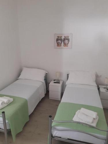 a bedroom with two beds and a table and a picture at Fronte Mare in Avola