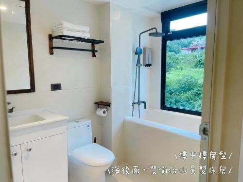 a bathroom with a toilet and a sink and a window at QBE 民宿 南灣館 QBE Nanwan in Nanwan