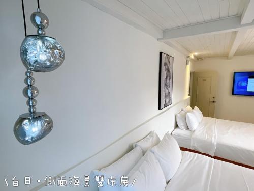a room with two beds and two lights on the wall at QBE 民宿 南灣館 QBE Nanwan in Nanwan