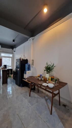 a living room with a table and a refrigerator at Casita Hostel House Bangkok in Bangkok