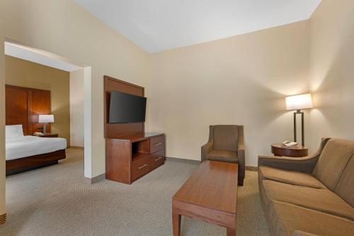 a hotel room with a couch and a tv and a bed at Comfort Suites South Bend Near Casino in South Bend