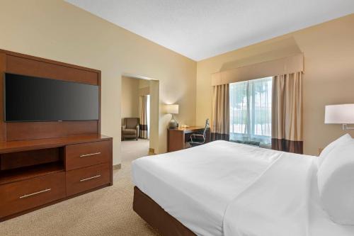 a hotel room with a bed and a flat screen tv at Comfort Suites South Bend Near Casino in South Bend