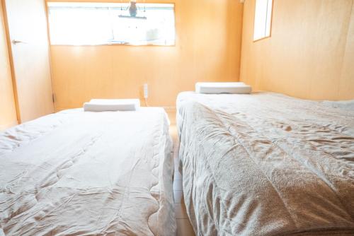 two beds sitting next to each other in a room at MF bloom in Minamiboso