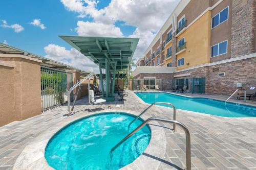 a swimming pool at a hotel with a building at Comfort Suites Ontario Airport Convention Center in Ontario