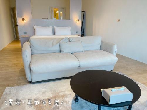 a living room with a white couch and a bed at QBE 民宿 南灣館 QBE Nanwan in Nanwan