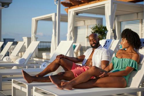 a man and a woman sitting on a beach chair at Hotel Effie Sandestin Resort, Autograph Collection in Destin
