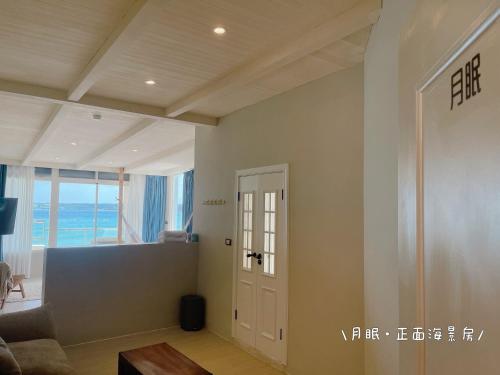 a living room with a door and a view of the ocean at QBE 民宿 南灣館 QBE Nanwan in Nanwan
