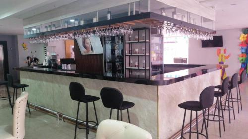 a bar with black stools in a room at Radisson Diamond Barranquilla in Barranquilla