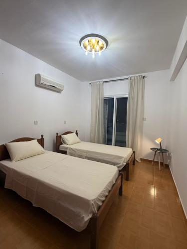 a room with two beds and a chandelier at Margarita Luxury 3 Bed & Pool in Dherinia