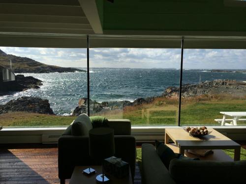 a living room with a large window looking out at the ocean at The Old Salt Box Co. - Grandma Lilly's in Fogo