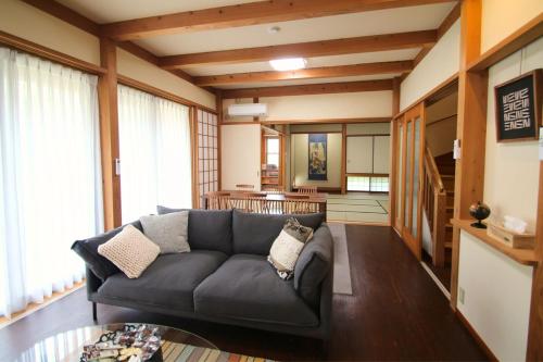 a living room with a couch and a table at Shinyashiki Guest House in Kumamoto