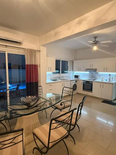 a large kitchen with a glass table and chairs at Margarita Luxury 3 Bed & Pool in Dherinia