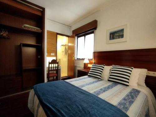 a bedroom with a large bed with blue and white sheets at Casa Hóspedes Polido in Termas de Sao Pedro do Sul