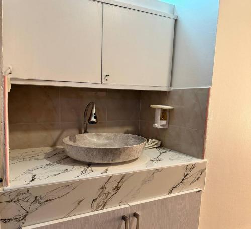 a bathroom with a stone sink on a counter at ATVR Juldis Tower Pratunam in Bangkok
