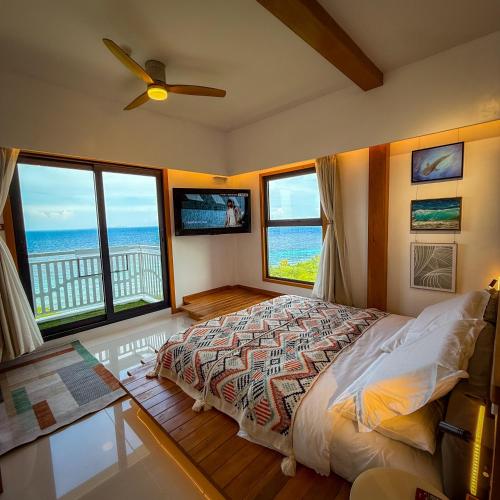 a bedroom with a bed with a view of the ocean at Aqua Horizon Beachside Condo I Signature Art Suites in Dauis