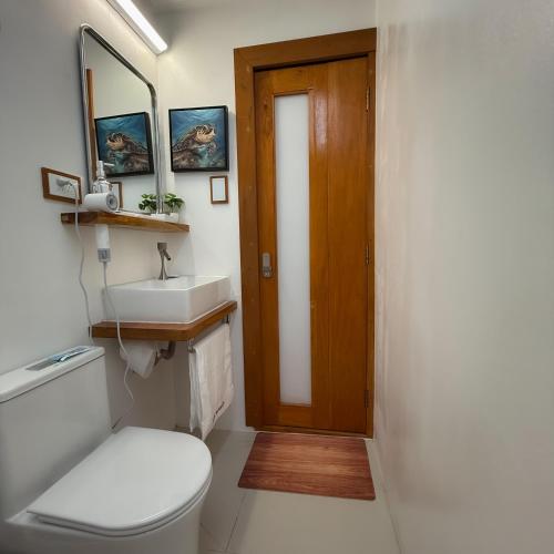 a bathroom with a toilet and a sink at Aqua Horizon Beachside Condo I Signature Art Suites in Dauis