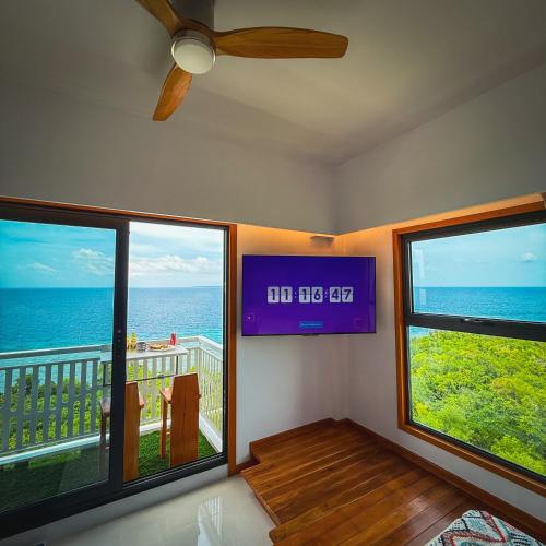 a living room with two windows and a view of the ocean at Aqua Horizon Beachside Condo I Signature Art Suites in Dauis