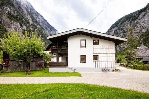 a white house in front of a mountain at W & S Executive Apartments - Hallstatt I in Hallstatt