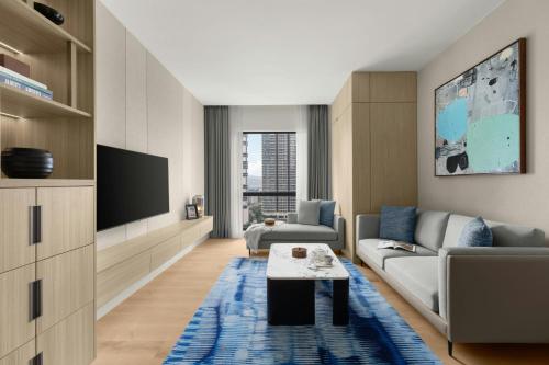 a living room with a couch and a tv at Marriott Executive Apartments Kuala Lumpur in Kuala Lumpur