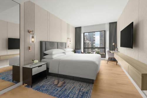 a bedroom with a white bed and a large window at Marriott Executive Apartments Kuala Lumpur in Kuala Lumpur