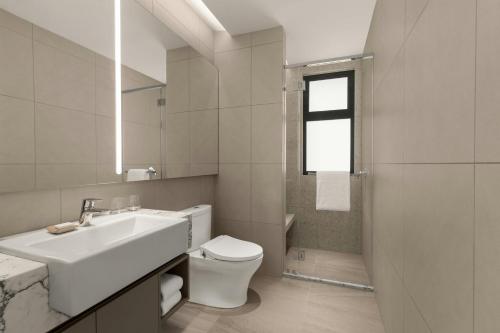 a white bathroom with a sink and a toilet at Marriott Executive Apartments Kuala Lumpur in Kuala Lumpur