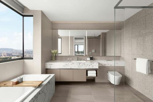 a bathroom with a tub and a toilet and a sink at Marriott Executive Apartments Kuala Lumpur in Kuala Lumpur
