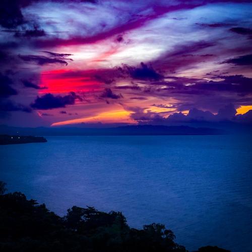 a sunset over a large body of water at Aqua Horizon Beachside Condo I Signature Art Suites in Dauis