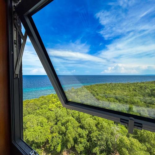 a view of the ocean from a window at Aqua Horizon Beachside Condo I Signature Art Suites in Dauis