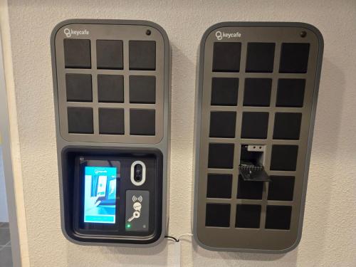 two cell phones are attached to a wall at M´s Stay Okinawa in Chatan