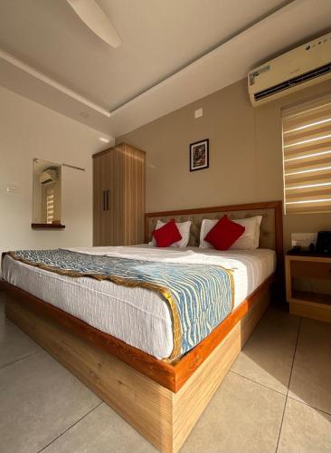 a bedroom with a large bed with red pillows at The Sea by Club Travalet in Alleppey
