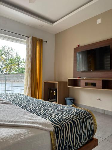 a bedroom with a bed and a large window at The Sea by Club Travalet in Alleppey