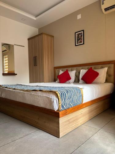 a bedroom with a wooden bed with red pillows at The Sea by Club Travalet in Alleppey