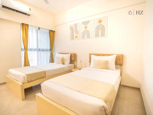 a bedroom with two beds and a window at Z Bliss Suites, BKC in Mumbai