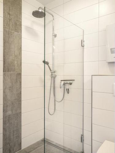 a shower with a glass door in a bathroom at Meerblick Lemkenhafen – Ferienwohnung in Fehmarn