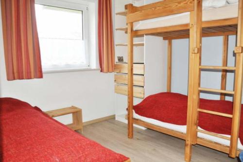 a bedroom with two bunk beds and a window at Seestern - Wassernah mit Garten und eingezäunter Terrasse in Gollendorf