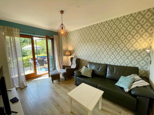 a living room with a green couch and a table at Lüttes Glück in Lemkenhafen in Lemkenhafen auf Fehmarn