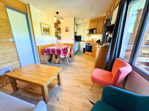 un salon avec une table et une cuisine dans l'établissement Résidence Necou - Appartement charmant pour 5 ski aux pieds MAE-4904, aux Menuires