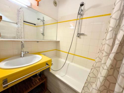 une salle de bain avec un lavabo et une baignoire dans l'établissement Résidence Necou - Appartement charmant pour 5 ski aux pieds MAE-4904, aux Menuires