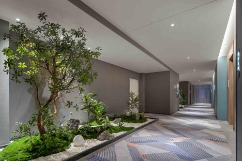 a hallway with a tree in the middle of a building at Holiday Inn Express Harbin Central Avenue by IHG in Harbin