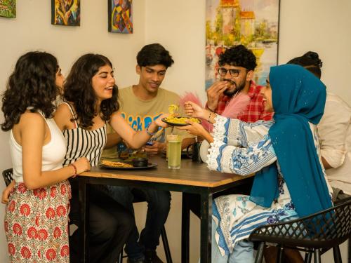 a group of people sitting around a table at The Hosteller Gokarna in Gokarna