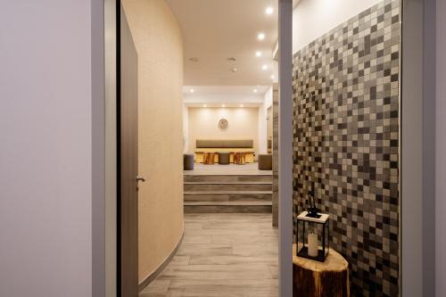a hallway with black tiles on the walls and a stairway at Boddenzeit - Moderne Ferienwohnung mit Nordbalkon, Wellnessbereich und Nähe zum Ostseestrand in Wustrow