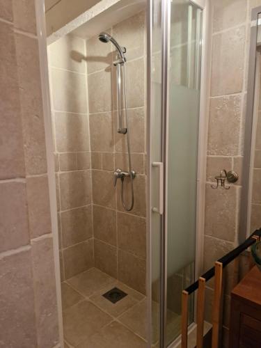 a shower with a glass door in a bathroom at Chambre d'hote in Saint-Dizant-du-Gua