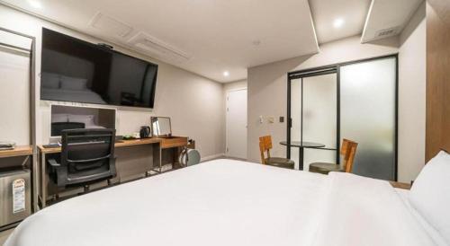 a hotel room with a bed and a desk with chairs at Seven Motel Ansan in Ansan