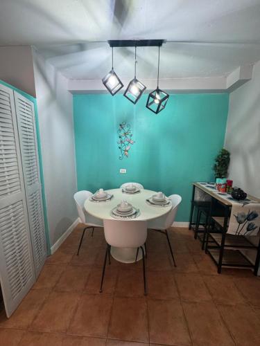 a table and chairs in a room with a blue wall at Spacious & Cozy 2 bedrooms Townhouse in gated community, excellent location in KGN8 in Kingston
