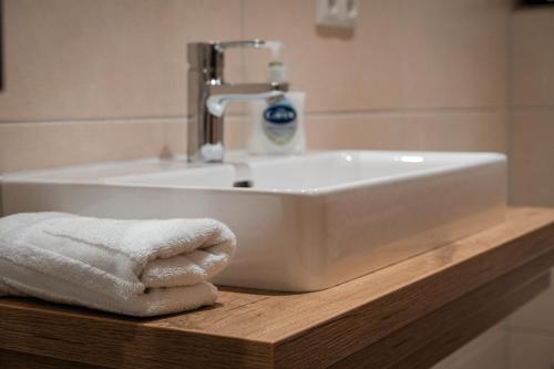 a bathroom sink with towels on a wooden counter at Bad Resort in Oberschneiding